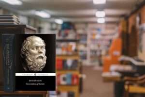 Xenophon book on library shelf, focused amidst blurred background